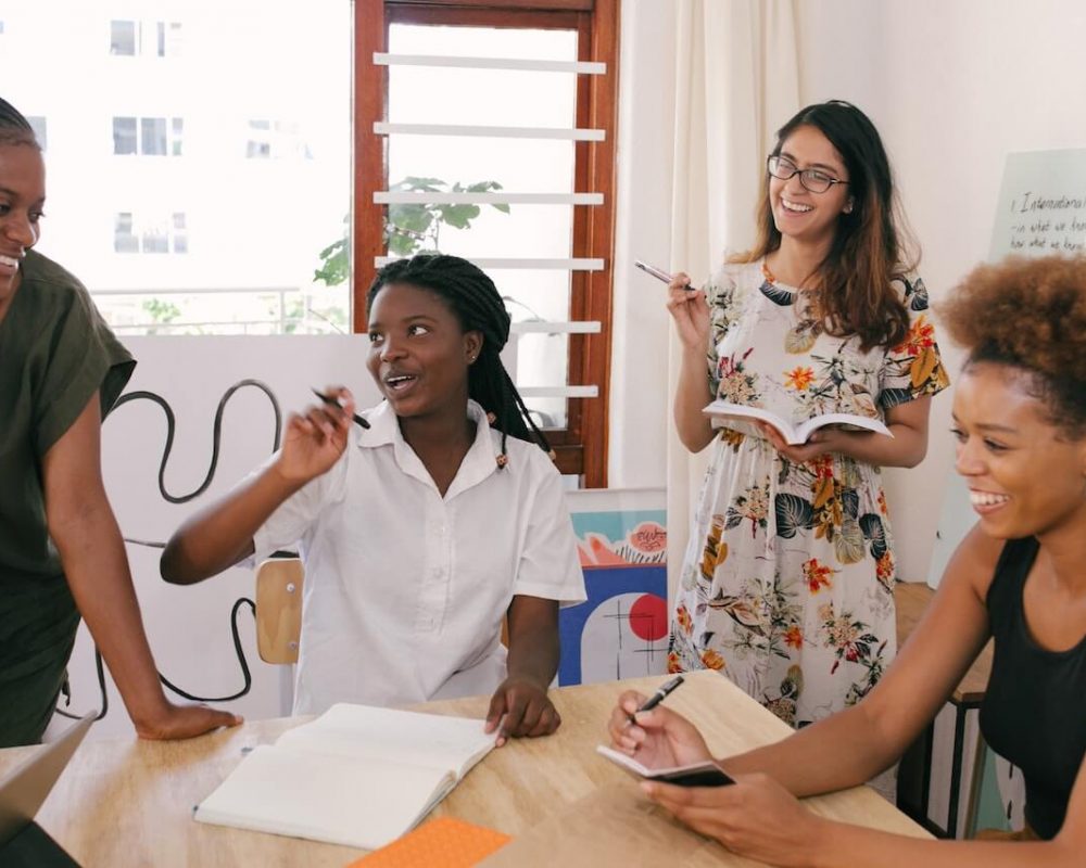 Multicultural women smiling and talking during business meeing